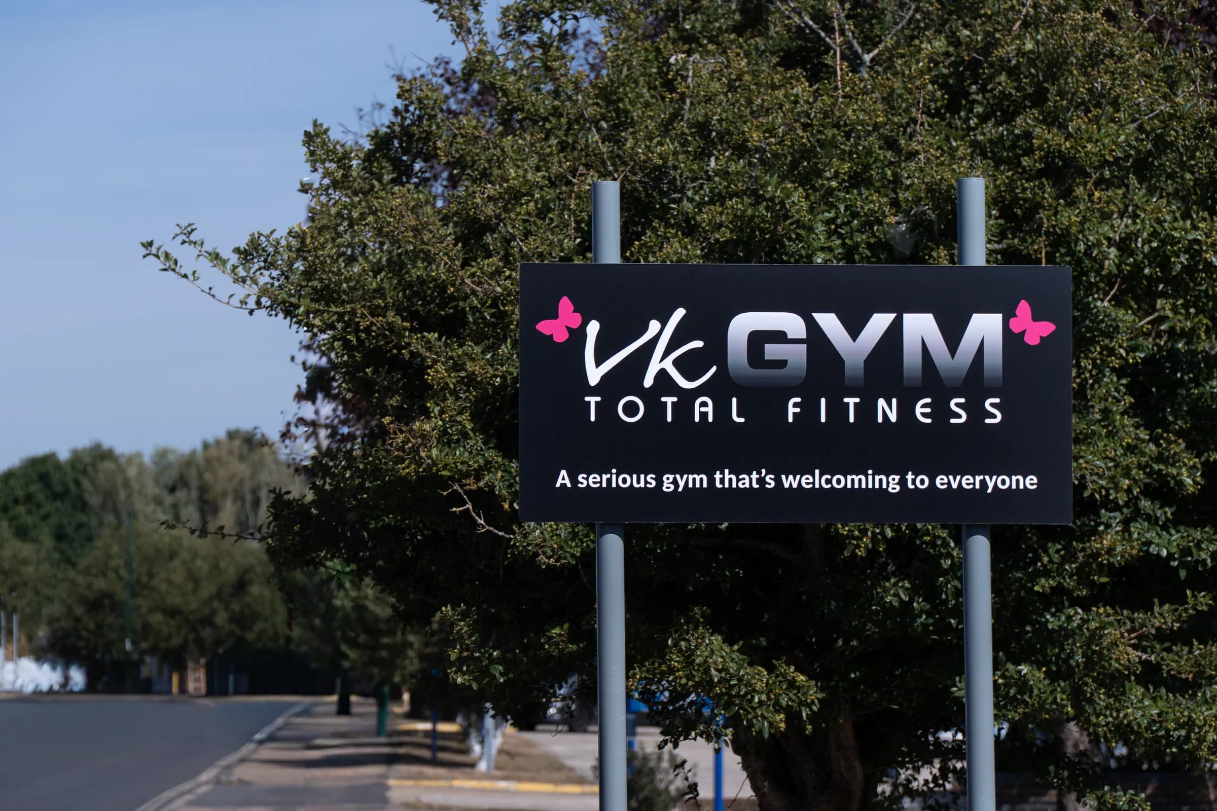 VK Gym Total Fitness roadside sign reading “A serious gym that’s welcoming to everyone”.
